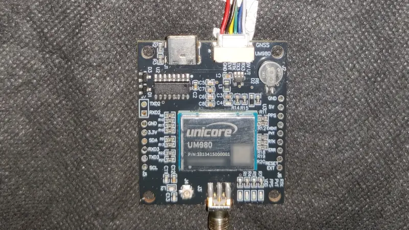 Unicore UM980 GNSS receiver board with wires running to an ESP32
