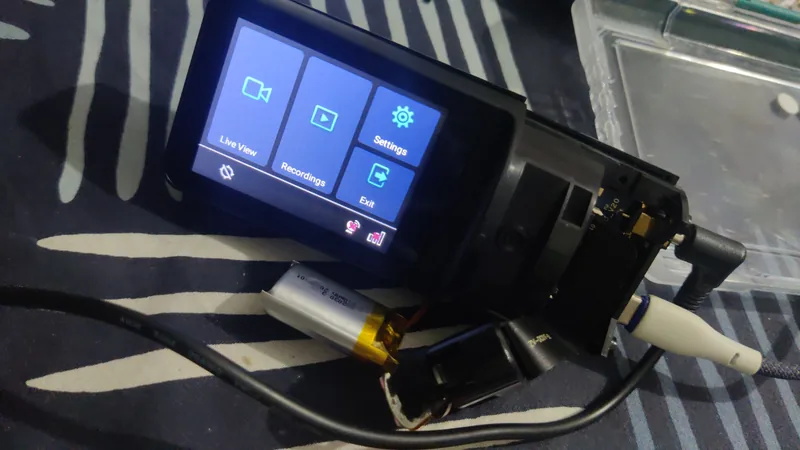 Surfsight AI-12 dashcam powered on with its case open, showing the home screen